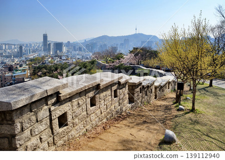 Seoul city wall in Naksan Park with cityscape and cherry blossom. Seoul city wall in Naksan Park with cityscape and cherry blossom. 139112940