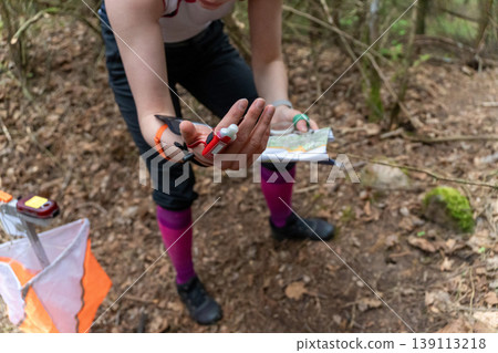an orienteer hands holding a map and electronic punch chip an orienteer hands holding a map and electronic punch chip 139113218