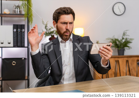 Middle-aged businessman watches clip on smartphone wearing wireless headphones dancing laughing fun 139113321