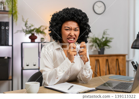 African American businesswoman crumples bill frustrated by mistake throws paper away upset at desk African American businesswoman crumples bill frustrated by mistake throws paper away upset at desk 139113322