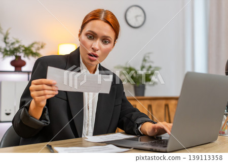 Young businesswoman finds unpaid bill makes rapid transfer on laptop sighs with relief after success Young businesswoman finds unpaid bill makes rapid transfer on laptop sighs with relief after success 139113358