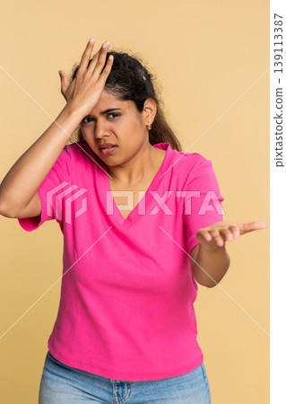 Indian woman dramatically does facepalm gesture, theatrically reacting to someone's foolish mistake Indian woman dramatically does facepalm gesture, theatrically reacting to someone's foolish mistake 139113387
