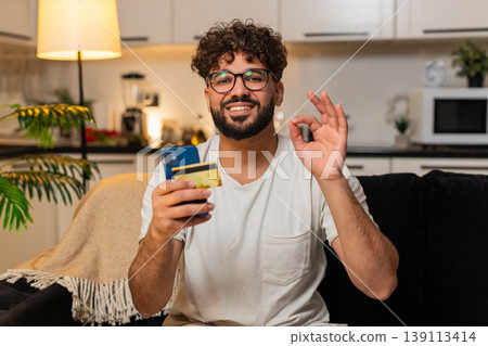 Arabian man confirms online payment with card on smartphone checks discount smiles stores e receipt 139113414