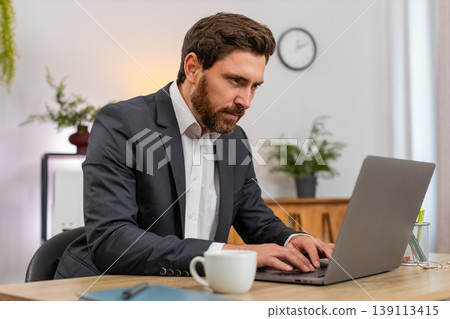 Middle-aged businessman rewrites polite complaint on laptop deletes phrase breathes calm typing soft Middle-aged businessman rewrites polite complaint on laptop deletes phrase breathes calm typing soft 139113415