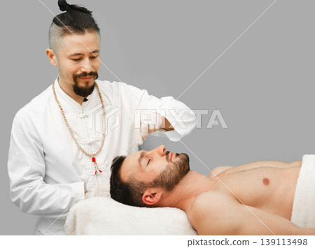 Man enjoys the acupuncture procedure. Acupuncturist doing acupuncture very accurately 139113498