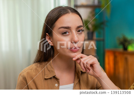 Young woman close up resting chin on hand thinking hard about solution looking for creative answer Young woman close up resting chin on hand thinking hard about solution looking for creative answer 139113508
