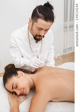 Reflexologist doing acupuncture to treat a woman patient. Acupuncture is part of traditional Chinese medicine Reflexologist doing acupuncture to treat a woman patient. Acupuncture is part of traditional Chinese medicine 139114144