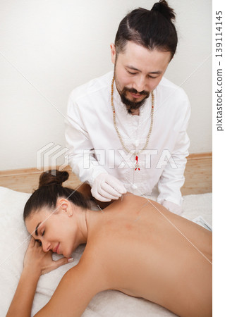Reflexologist doing an acupuncture procedure. Stress relief with acupuncture. Traditional chinese medicine Reflexologist doing an acupuncture procedure. Stress relief with acupuncture. Traditional chinese medicine 139114145