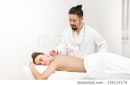 Traditional Chinese medicine doctor doing massage with vacuum cups to a female patient. Health recovery woman with vacuum cups. 139114174
