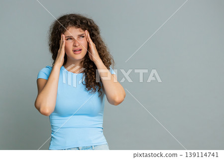 Woman suffering headache stress holding head closing eyes painful tired exhausted facial reaction 139114741