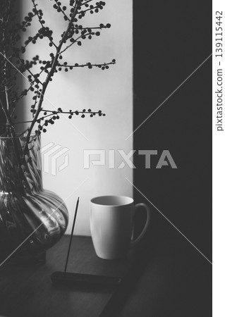 Minimalist black and white still life with a white ceramic mug, glass vase with dry branches, and soft morning shadows. Atmospheric moody aesthetic for wellness, slow living, and cozy home decor. Minimalist black and white still life with a white ceramic mug, glass vase with dry branches, and soft morning shadows. Atmospheric moody aesthetic for wellness, slow living, and cozy home decor. 139115442