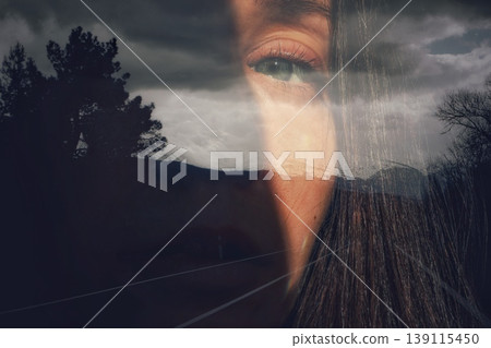 Double exposure portrait of woman eye merged with dark stormy landscape, forest, and road. Conceptual art of inner world, and connection with nature. 139115450