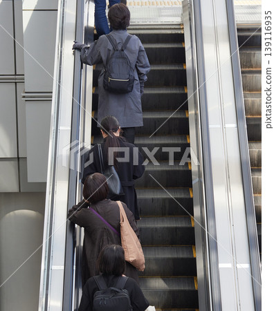 A young female office worker on her way to work is seen riding an escalator in a commercial facility in front of Nagoya Station. A young female office worker on her way to work is seen riding an escalator in a commercial facility in front of Nagoya Station. 139116935