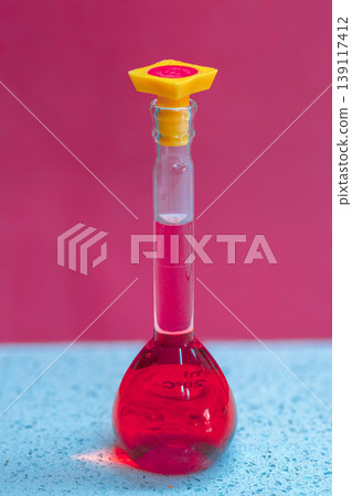 Scientific beaker containing vibrant red liquid, symbolizing chemistry research, laboratory experiments, medicine development, and scientific discovery in a clear glass flask 139117412