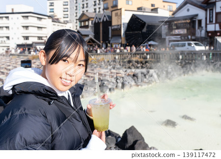 A teenage girl visiting the Yubatake hot springs on a trip to Kusatsu Onsen A teenage girl visiting the Yubatake hot springs on a trip to Kusatsu Onsen 139117472
