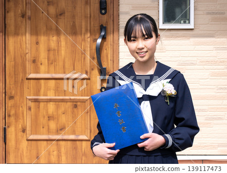 A middle school girl holding her graduation certificate A middle school girl holding her graduation certificate 139117473