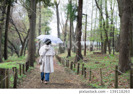A video of a calm, healthy, and active senior citizen, an elderly woman, taking a walk with an umbrella; the rainy season and rain do not affect her. A video of a calm, healthy, and active senior citizen, an elderly woman, taking a walk with an umbrella; the rainy season and rain do not affect her. 139118263