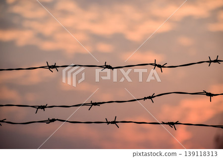 Close-up of the fence with the sunset sky. Sunset background, colorful sky. Close-up of the fence with the sunset sky. Sunset background, colorful sky. 139118313