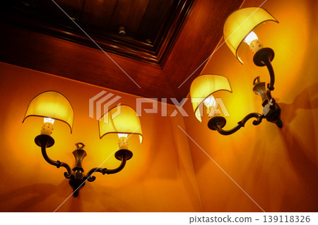 Close-up of the lamp hanging on the wall indoors. Interior design, indoor decoration.  139118326