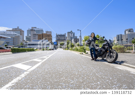 城市景觀,一位女騎士站在一輛巡航自行車上。 城市景觀,一位女騎士站在一輛巡航自行車上。 139118732