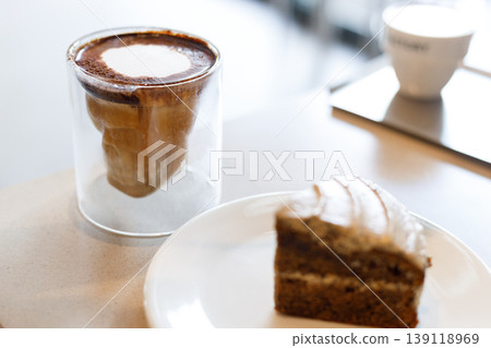 Chilled milk coffee in skull shape cup on table by the window. Chilled milk coffee in skull shape cup on table by the window. 139118969