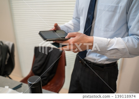 Businessmen checking their smartphones Businessmen checking their smartphones 139118974
