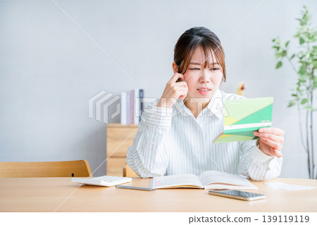 A woman holding a household account book A woman holding a household account book 139119119