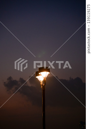 Close-up of the street light at night. City street lamp post in the street at night. Cityscape and lighting scene. Close-up of the street light at night. City street lamp post in the street at night. Cityscape and lighting scene. 139119275