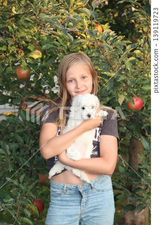 Young girl posing with Maltipoo puppy. Girl loving her pet.Stylish girl with dog Young girl posing with Maltipoo puppy. Girl loving her pet.Stylish girl with dog 139119723