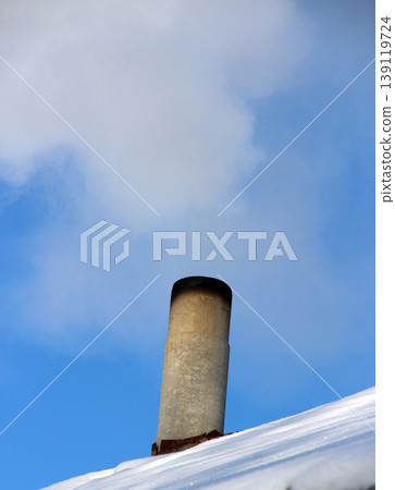 Smoke coming out of the chimney on the roof of private house. CO2 emissions Smoke coming out of the chimney on the roof of private house. CO2 emissions 139119724