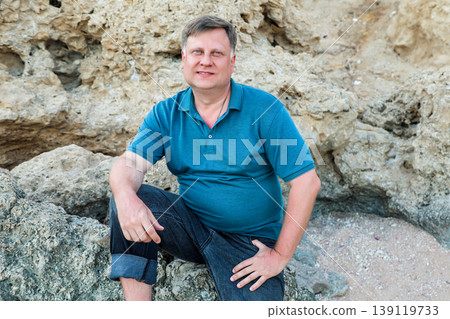 Man in a blue shirt portrait near a cliff 139119733