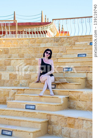 A woman in a bikini on the steps of the old amphitheater 139119740