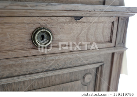Keyholes in wooden furniture. Antique drawer hardware. Decorative brass keyholes. Keyholes in wooden furniture. Antique drawer hardware. Decorative brass keyholes. 139119796