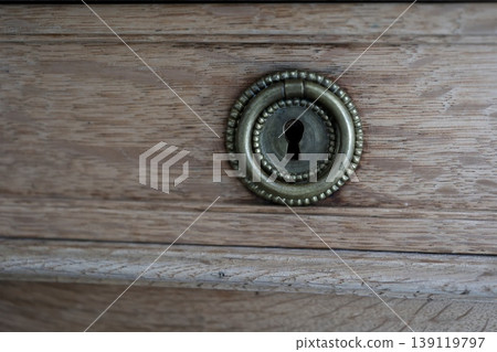 Keyhole on a wooden drawer. Antique brass fittings. Classic design. Keyhole on a wooden drawer. Antique brass fittings. Classic design. 139119797