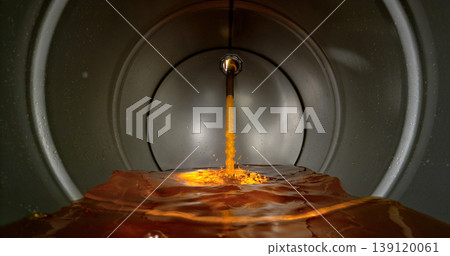 Gasoline jet pouring into metal fuel tank, inside view with dynamic splash and turbulence. Concept of refueling, fuel storage and energy supply, industrial environment. Gasoline jet pouring into metal fuel tank, inside view with dynamic splash and turbulence. Concept of refueling, fuel storage and energy supply, industrial environment. 139120061