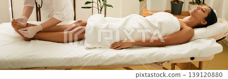 Asian woman enjoys acupuncture procedure lying on massage table at wellness spa Asian woman enjoys acupuncture procedure lying on massage table at wellness spa 139120880