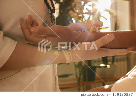 Chiropractor inserts acupuncture needle into patient's hand. Acupuncture treatment, reflexology, alternative medicine Chiropractor inserts acupuncture needle into patient's hand. Acupuncture treatment, reflexology, alternative medicine 139120887