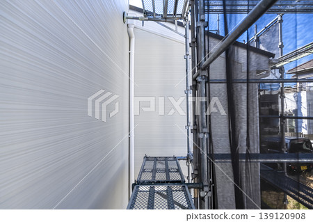 Rain gutters and new exterior walls for a detached house; exterior construction with scaffolding. Rain gutters and new exterior walls for a detached house; exterior construction with scaffolding. 139120908