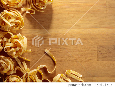 Raw dry noodles on a wooden table. Raw dry noodles on a wooden table. 139121307