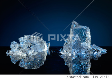 Broken ice on a black reflective background, with blue lighting. 139121318