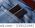 Black DDR5 RAM memory modules placed inside a jeans pocket. RAM shortages on the market, rising prices, and increased demand driven by the growing need for AI training. 139121441