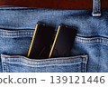 Black DDR5 RAM memory modules placed inside a jeans pocket. RAM shortages on the market, rising prices, and increased demand driven by the growing need for AI training. 139121446