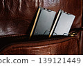 Black DDR5 RAM memory modules placed inside a brown leather bag pocket. RAM shortages on the market, rising prices, and increased demand driven by the growing need for AI training. 139121449