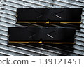 Black DDR5 RAM memory modules placed on a aluminum radiator. RAM shortages on the market, rising prices, and increased demand driven by the growing need for AI training. 139121451
