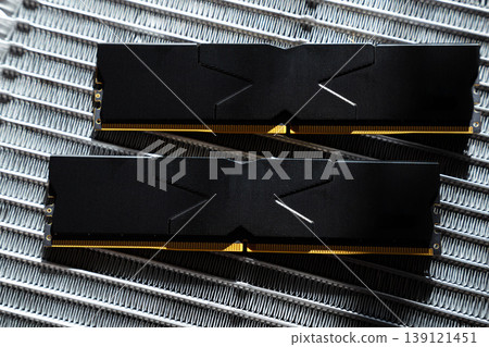 Black DDR5 RAM memory modules placed on a aluminum radiator. RAM shortages on the market, rising prices, and increased demand driven by the growing need for AI training. 139121451