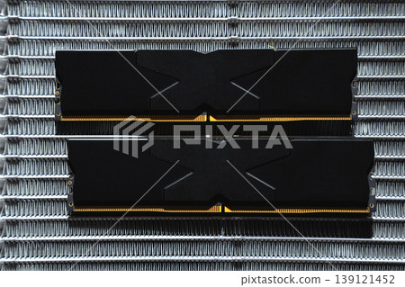 Black DDR5 RAM memory modules placed on a aluminum radiator. RAM shortages on the market, rising prices, and increased demand driven by the growing need for AI training. Black DDR5 RAM memory modules placed on a aluminum radiator. RAM shortages on the market, rising prices, and increased demand driven by the growing need for AI training. 139121452