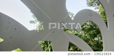 View of green foliage through decorative laser cut panel with abstract pattern View of green foliage through decorative laser cut panel with abstract pattern 139121624