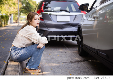 Upset woman waiting for roadside assistance after car crash Upset woman waiting for roadside assistance after car crash 139121692
