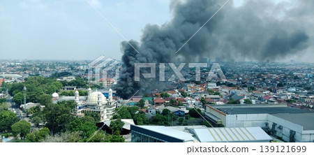 Thick black smoke billows from a fire in a residential area in Jakarta. Thick black smoke billows from a fire in a residential area in Jakarta. 139121699