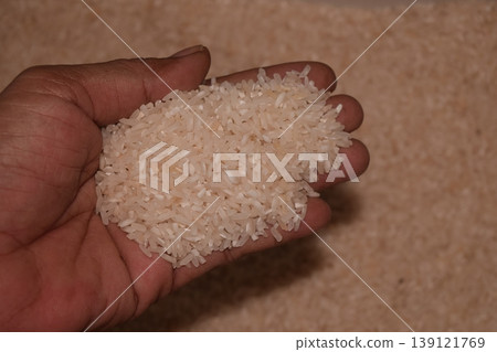 Rice grain in hands, isolated on a blur background. Rice grain in hands, isolated on a blur background. 139121769